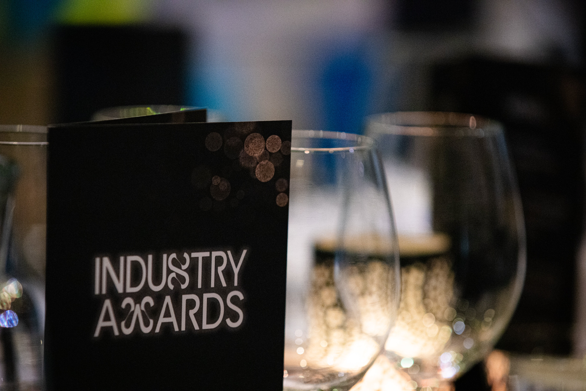 Industry Awards -menukortti ja viinilaseja gaalan illallispöydän päällä